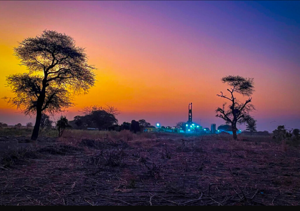 A wide angle view of Helium One's ITW-1 weel site in the southern Rukwa Basin, silhouetted against a vivid sunset sky.